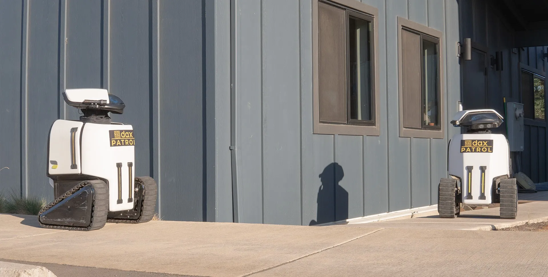 Two Dax patrol robots outside a commercial building