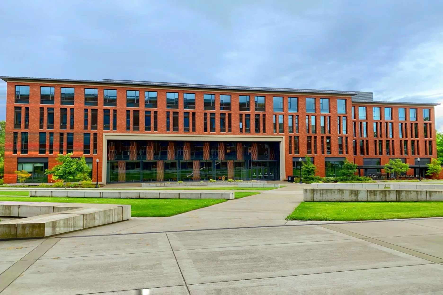 A brick university building behind a wide campus plaza